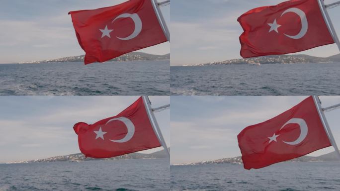 美丽的阳光下，土耳其国旗在风中飘扬的船巡航在夏天的大海和城市的背景