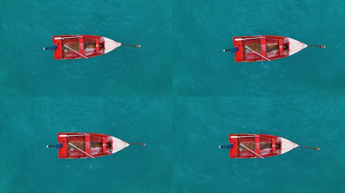 旧的红色木船，脏水系在浮标上，油漆脱落，桨留在里面，空中俯瞰