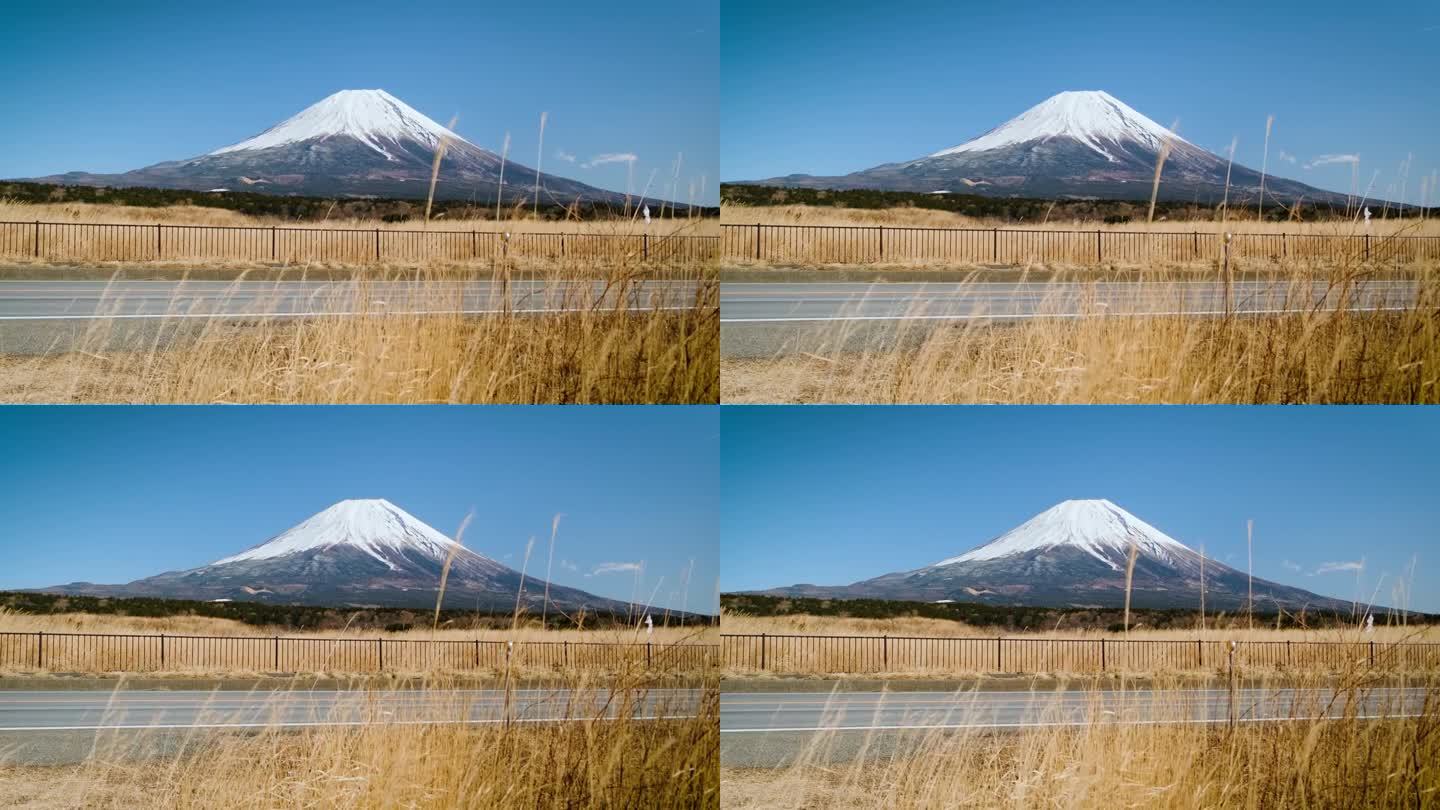 在蓝天的日子里，富士山映衬着群山和草地，是游客和旅行者的地标和目的地。大自然的美在平和中伴着缓慢的冬