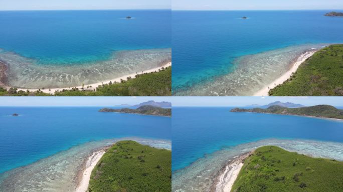 斐济岛的鸟瞰图，以白色的沙滩为特征，周围是清澈的浅水，随着海岸的延伸，浅水逐渐变成深蓝色。