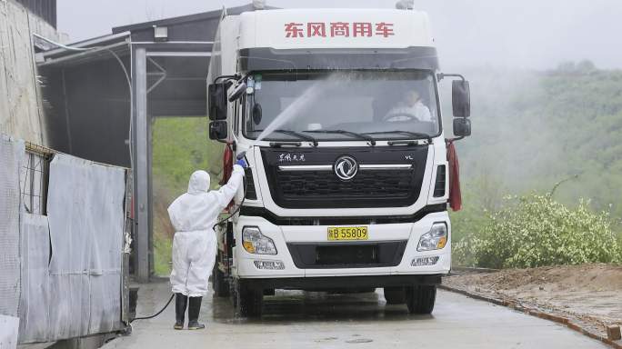 养殖场防疫人员检查清洗饲料运输车