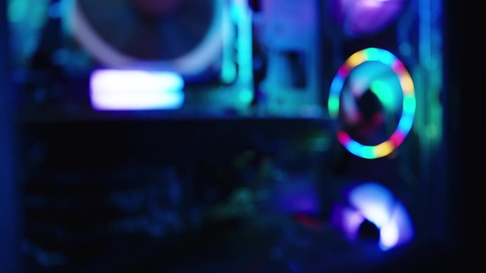 科技视频的背景，个人电脑的内部组件，黑暗中游戏电脑的彩虹灯光。焦距不清。