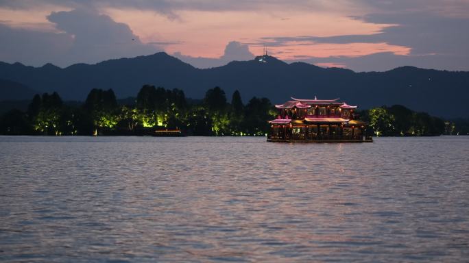 黄昏日暮时的中国杭州西湖和湖面上的游船