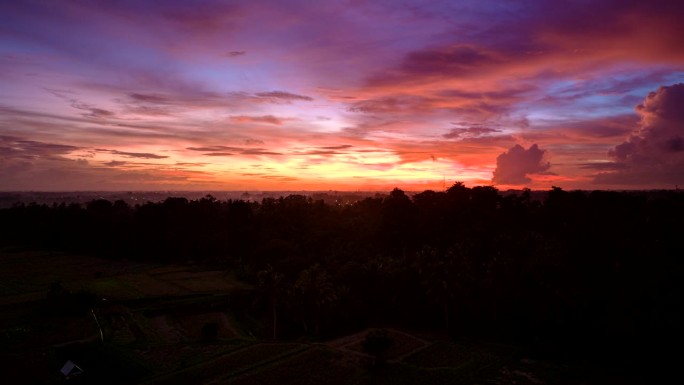 巴厘岛印尼乌布村日落时彩色天空的超延时延时。空中前进。从早到晚