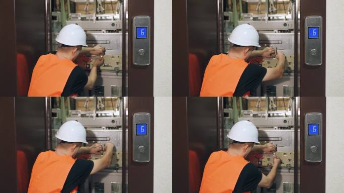 安装复杂的现代化电梯设备，调试电梯部件。一名男性公用事业工人正在修理电梯，电梯门开着。