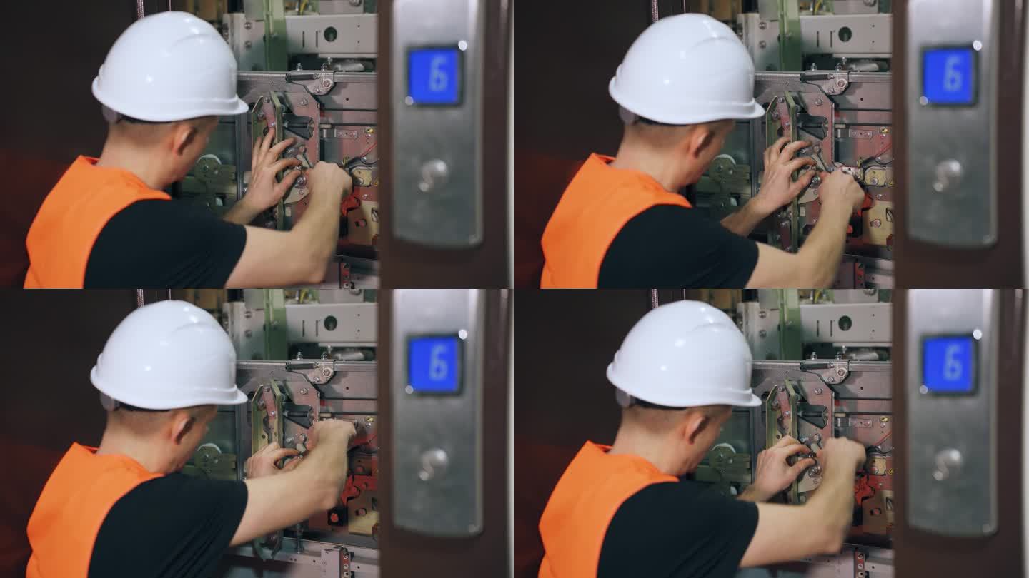 维修工程师正在修理电梯，电梯门是开着的。修理工用扳手调整电梯的安全系统。由专业人员安装复杂的设备。
