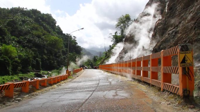 炙热的蒸汽从菲律宾著名的巴伦西亚东内格罗斯火山喷出。路边的栅栏，用来保护行人和车辆。