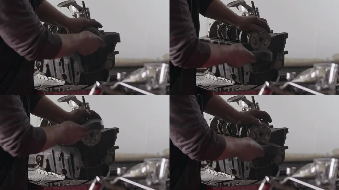机械师在修理厂用铁锤修理汽车发动机缸体零件