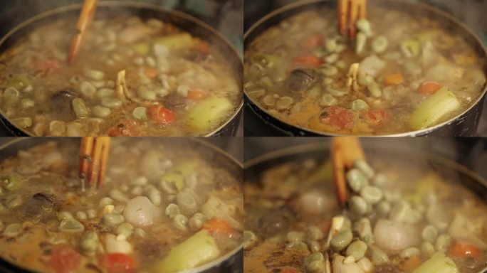 厨房炉子上热气腾腾的锅里的炖豆和蔬菜的特写。