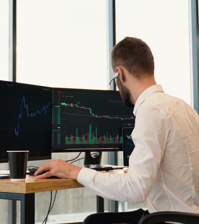 集中交易者坐在电脑前，做专业的烛台图分析，制定策略。垂直视频