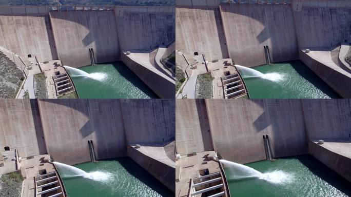 重力坝放水。豪厄尔饥饿阀工作。下降鸟瞰图在大坝和河流。可再生能源。水电站。到站
