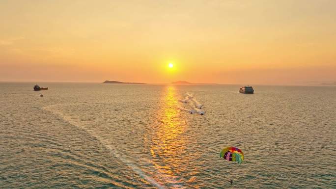 海南三亚橘红色夕阳晚霞行驶的巨型豪华游艇