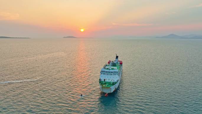 海南三亚橘红色夕阳晚霞行驶的巨型豪华游艇