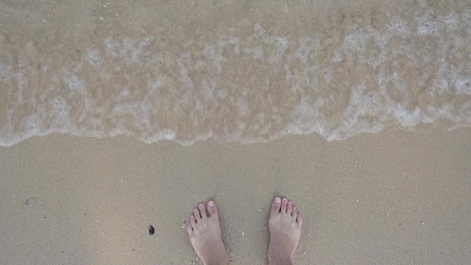 慢动作场景，近距离拍摄赤脚在夏季海上旅行的沙滩上