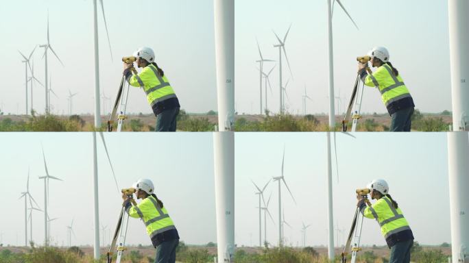 4K女工程师使用测量设备水平经纬仪在风力发电厂工作
