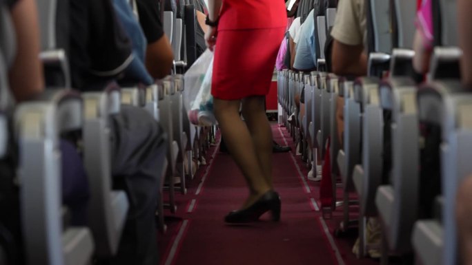 中景:身穿红色套装的空姐或空乘手持不透明垃圾袋