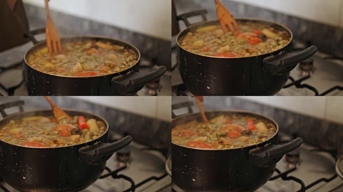 用木勺手工搅拌自制的豆子和蔬菜炖菜，用小火慢炖