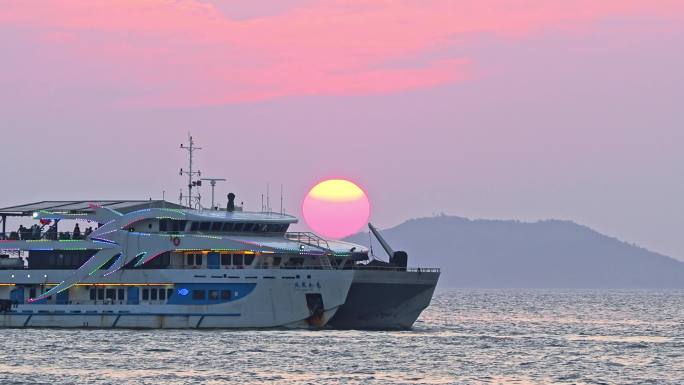 海南三亚橘红色夕阳晚霞行驶的巨型豪华游艇