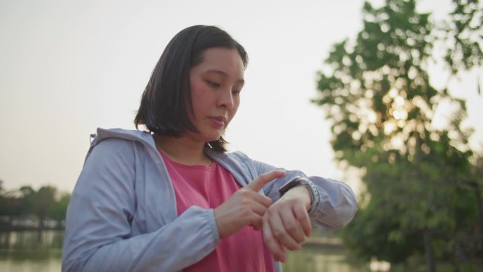 亚洲体育女子在智能手表上监测她的跑步表现