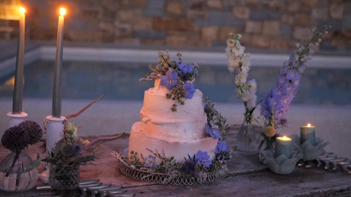 池边的乡村婚礼蛋糕和野生波西米亚花，晚上的婚宴