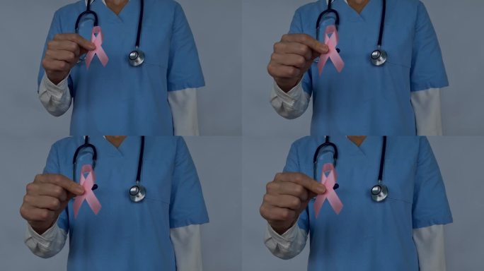 医生拿着女性乳房和粉色结的人工模型