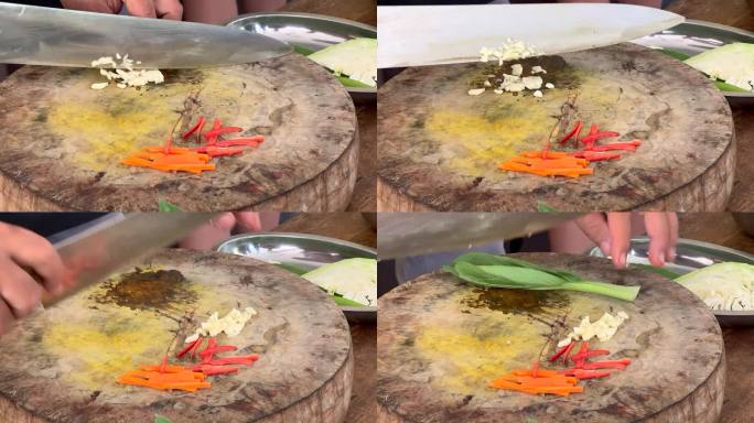 亚洲厨师熟练地用一把大刀在砧板上切大蒜，然后切白菜叶