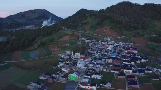 鸟瞰图，一个村庄在黎明的薄雾中，周围是田野和山丘。迪昂高原山，印度尼西亚。