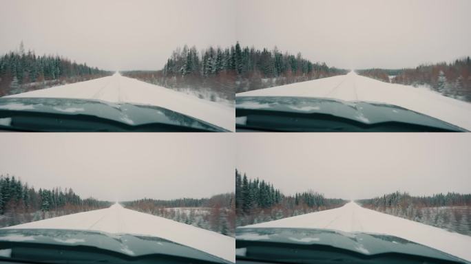 卡车行驶在白雪覆盖的冬季公路上，两边都是树木