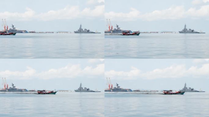 在西哈努克港航行的彩色小船。背景中有两艘日本驱逐舰在停靠