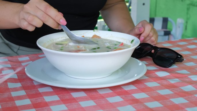 一名女子在泰国咖啡馆喝汤