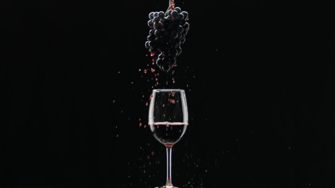 红酒玻璃杯上挂着一串葡萄。品尝奢侈的葡萄。