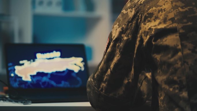 一个军人在电脑前工作，收集有关俄罗斯的情报数据