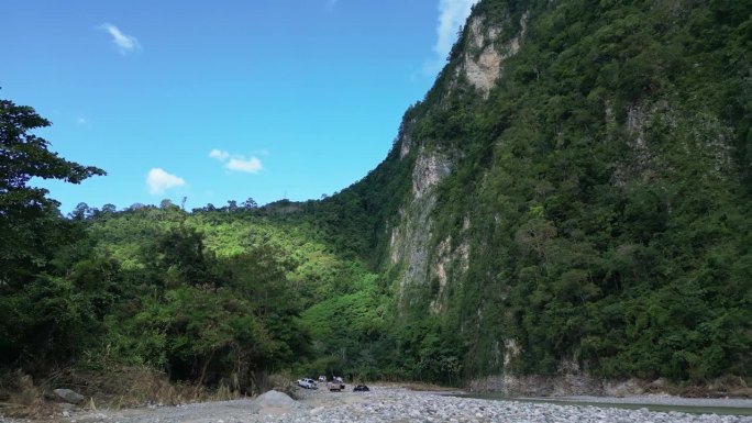 在多米尼加共和国的穆夏斯阿瓜斯河岸边，人们开着越野车。低空前飞