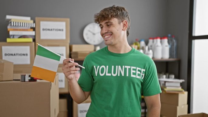 微笑的年轻西班牙人在慈善中心做志愿者，自豪地举着爱尔兰国旗