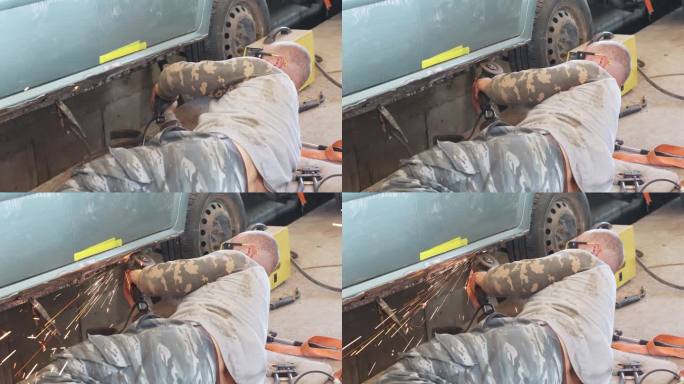 机械师用磨床除去汽车上的锈。