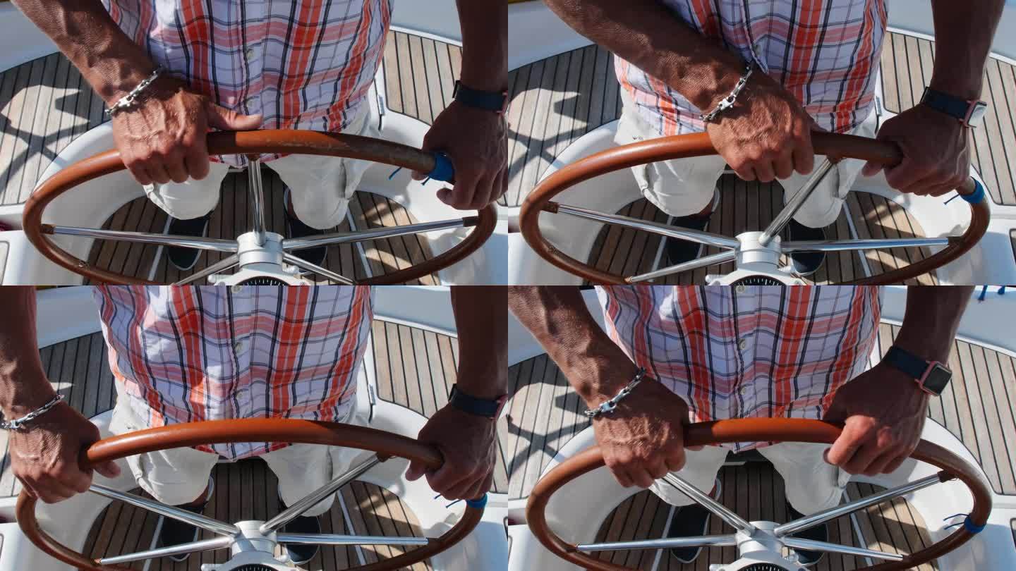 强壮的帆船运动员熟练地用轮子驾驶船