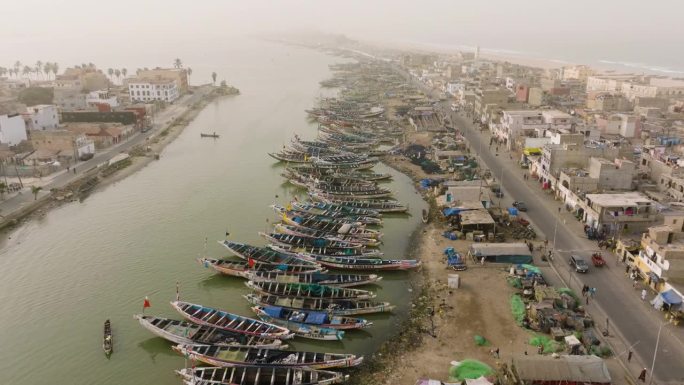 航拍缩小。色彩斑斓的独木舟停泊在被污染的塞内加尔河上。塑料污染，塞内加尔圣路易，联合国教科文组织世界