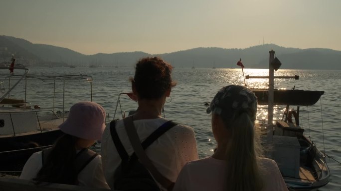 一家人站在停泊的游艇旁。