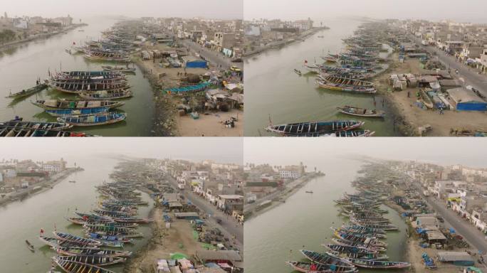 空中摇上。色彩斑斓的独木舟停泊在被污染的塞内加尔河上。塑料污染，塞内加尔圣路易，联合国教科文组织世界
