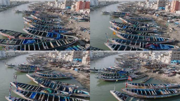 近距离空中飞行。色彩斑斓的独木舟停泊在被污染的塞内加尔河上。塑料污染，塞内加尔圣路易，联合国教科文组