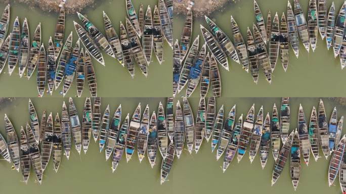 空中特写镜头直接向下平移。色彩斑斓的独木舟停泊在被污染的塞内加尔河上。塑料污染，塞内加尔圣路易，联合