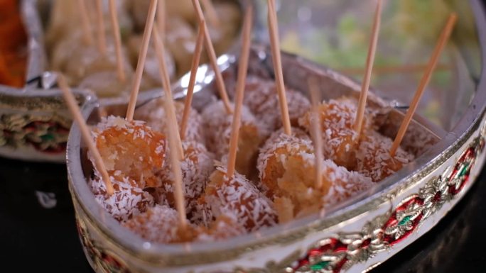 婚礼上美味的印度甜点Gulab Jamun配椰子棒。特写镜头