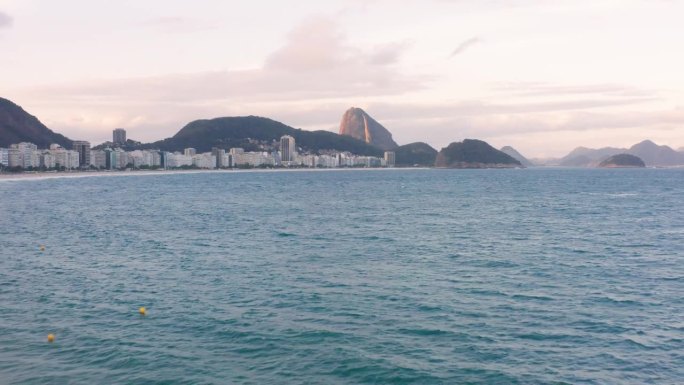 白天，里约热内卢的科帕卡巴纳海滩风景如画，对面是甜面包山