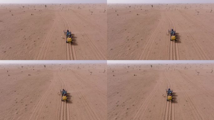 航拍后视图。在塞内加尔撒哈拉沙漠萨赫勒地区贫瘠的土地上，两个黑人拉着满载饮用水的驴车返回他们的村庄。