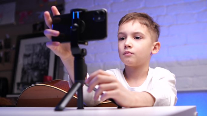 小男孩通过手机应用上的在线课程学习弹吉他