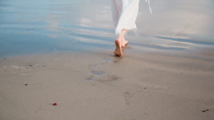 女孩赤脚行走在海边沙滩特写情绪脚印