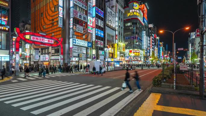 在日本东京新宿，人们穿过歌舞伎町门前繁忙的街道
