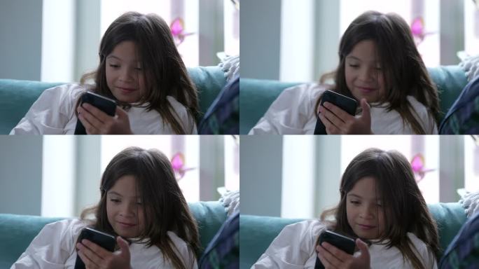 孩子对在线内容的反应是坐在家里的沙发上通过手机观看媒体。小女孩沉迷于现代科技，被娱乐分散了注意力，自