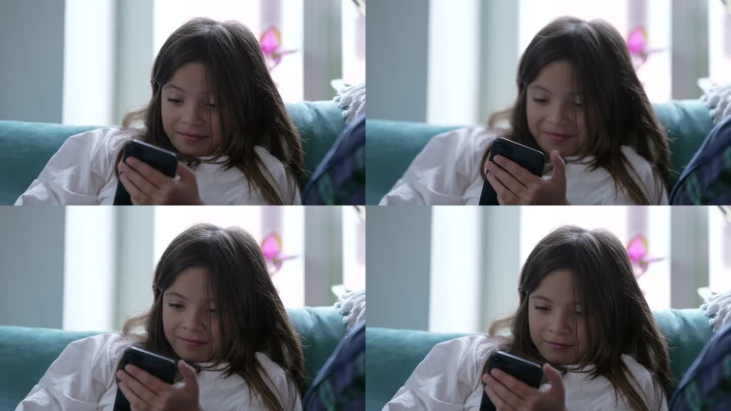 孩子对在线内容的反应是坐在家里的沙发上通过手机观看媒体。小女孩沉迷于现代科技，被娱乐分散了注意力，自