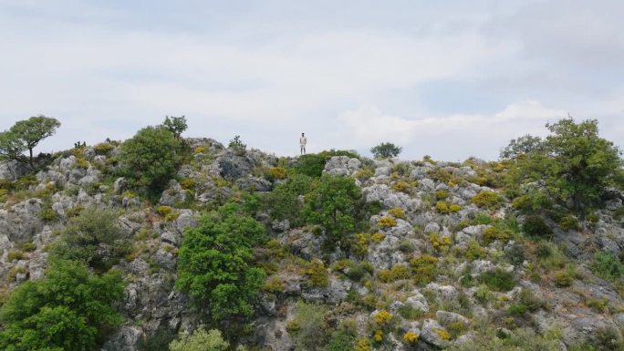 男人站在美丽的海景上，年轻人站在山顶上欣赏风景，男人站在高处自由地看风景，自由地站在大自然中